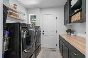 Clothes washing area featuring cabinets, independent washer and dryer, and light hardwood / wood-style floors