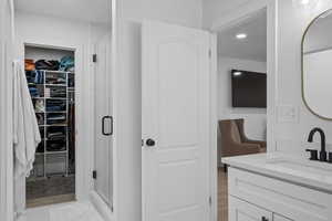 Bathroom featuring vanity and a shower with door