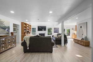 Living room featuring a textured ceiling and light hardwood / wood-style floors