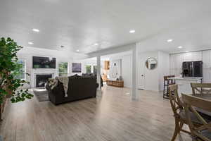 Living room with a textured ceiling and light hardwood / wood-style flooring