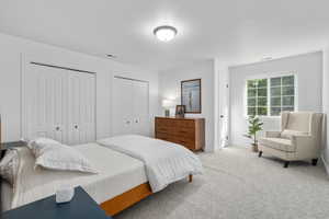 Bedroom with multiple closets and carpet floors