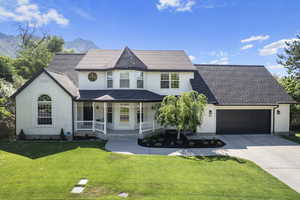 Victorian house featuring a mountain view, a garage, covered porch, and a front yard