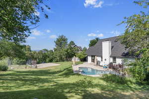 View of swimming pool featuring a patio area and a lawn