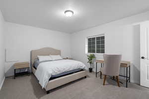 Bedroom featuring light carpet