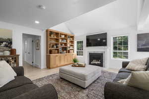 Living room featuring a healthy amount of sunlight, vaulted ceiling, and light hardwood / wood-style floors