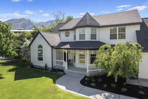 View of front of house featuring a mountain view, covered porch, and a front yard