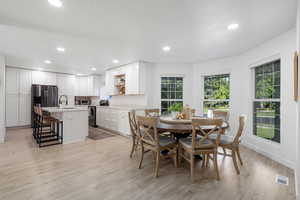 Dining space with sink and light hardwood / wood-style flooring