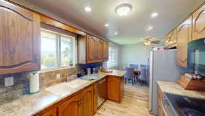 Kitchen featuring ceiling fan, dishwasher, sink, light hardwood / wood-style floors, and decorative backsplash