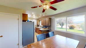 Dining area with a textured ceiling, ceiling fan, and sink