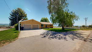 Ranch-style home featuring a garage and a front lawn