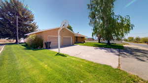 View of side of home with a garage and a yard