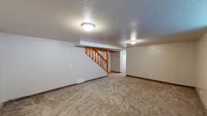 Basement with carpet and a textured ceiling