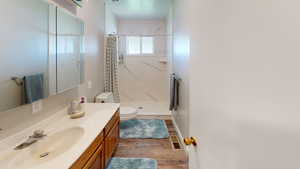 Bathroom featuring hardwood / wood-style floors, vanity, toilet, and walk in shower