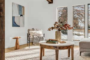 Living area featuring beam ceiling and hardwood / wood-style floors