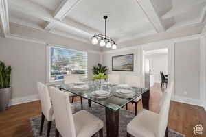 Dining room with beam ceiling, crown molding, dark hardwood / wood-style flooring, and coffered ceiling