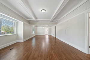 Unfurnished room with coffered ceiling, beamed ceiling, dark hardwood / wood-style floors, and ornamental molding