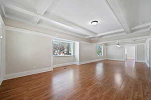 Unfurnished living room with beamed ceiling, hardwood / wood-style floors, and coffered ceiling