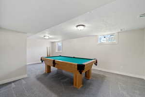 Rec room with carpet flooring, a textured ceiling, a healthy amount of sunlight, and billiards