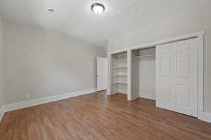 Unfurnished bedroom featuring hardwood / wood-style floors and a textured ceiling