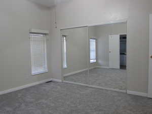 Master bedroom featuring new carpet, new paint, and mirrored closet doors