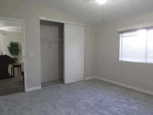 Bedroom #2 featuring new carpet, lofted ceiling, and a closet