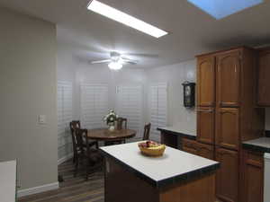 Kitchen & Dining area featuring ceiling fan, a center island, and dark wood-type flooring