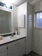 Master Bathroom featuring vanity, lots of extra storage, wood-type flooring, and an enclosed shower