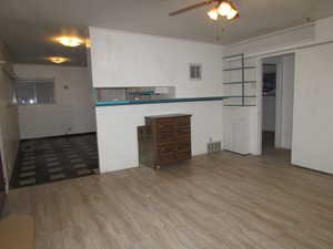 Apartment - living room featuring built-in shelving, tile wood-style floors, and ceiling fan