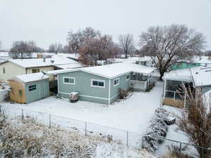 Snow covered property with an outbuilding