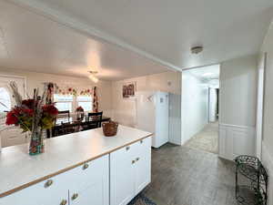 Kitchen featuring hardwood / wood-style flooring, white cabinets, and white refrigerator