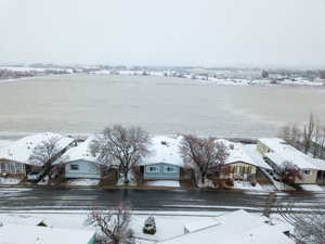 Snowy aerial view with a water view