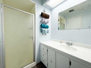 Bathroom featuring vanity and a shower with shower door