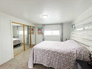 Carpeted bedroom featuring a closet