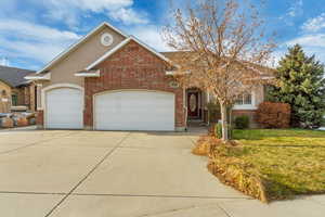 View of front of property featuring a front yard and a garage