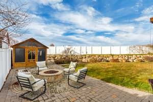 View of patio with a fire pit and jacuzzi gazebo.