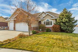 View of front of property featuring a front yard and a garage