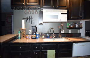 Kitchen featuring white appliances and sink