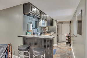 Second Kitchen with a kitchen breakfast bar, kitchen peninsula, and sink, fridge and stove.