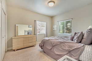 Bedroom featuring light colored carpet and a closet