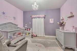 Bedroom with a chandelier and a nursery area