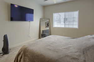 Carpeted bedroom featuring ceiling fan