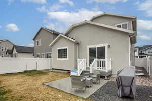 Back of house with a yard and a patio