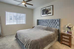 Carpeted bedroom featuring ceiling fan