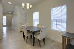 Dining space featuring a wealth of natural light, light hardwood / wood-style floors, and a notable chandelier