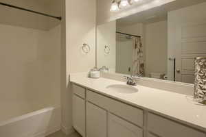 Full bathroom featuring shower / bath combo, vanity, and toilet