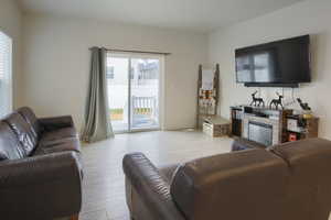 Living room with a stone fireplace and light wood-type flooring