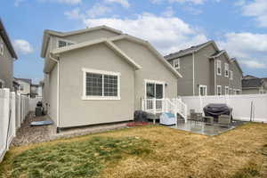 Rear view of property with a lawn, central air condition unit, and a patio