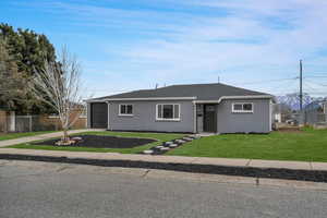 Ranch-style home featuring a front lawn