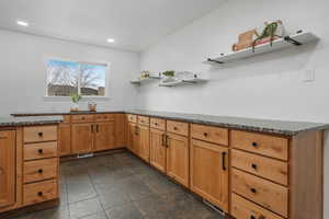 Kitchen featuring dark stone counters
