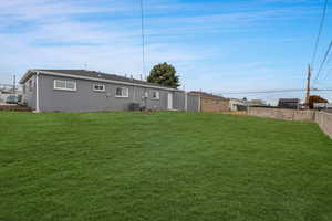 Back of house with a yard and new central air condition unit